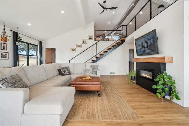 living room featuring hardwood / wood-style flooring, high vaulted ceiling, and beam ceiling