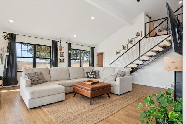 living room with hardwood / wood-style flooring, beam ceiling, and high vaulted ceiling