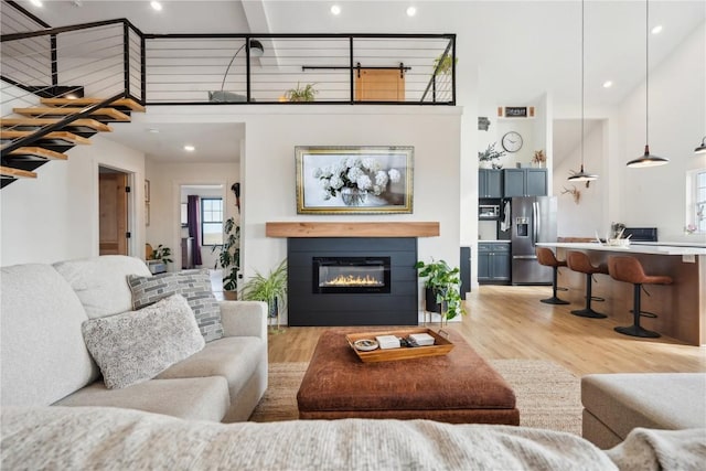 living room featuring a towering ceiling and light hardwood / wood-style floors