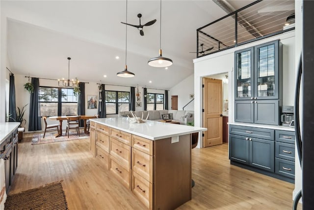 kitchen featuring a kitchen island, pendant lighting, light brown cabinets, and light hardwood / wood-style floors