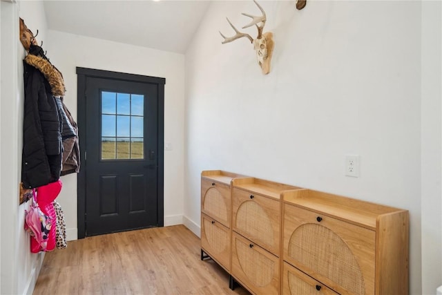 doorway to outside with lofted ceiling and light hardwood / wood-style floors