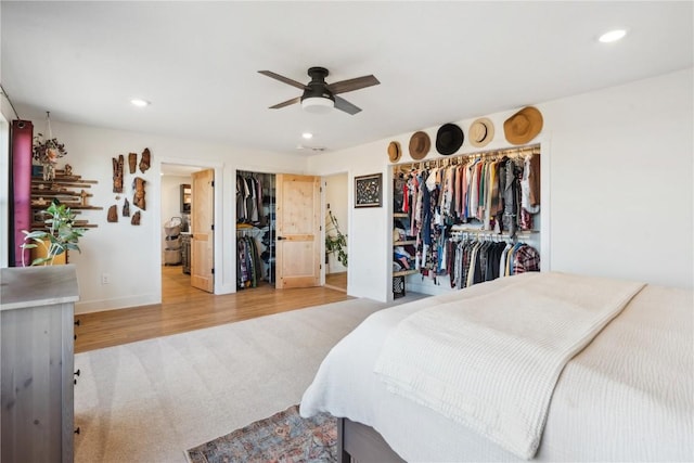 bedroom with ceiling fan, connected bathroom, and hardwood / wood-style floors