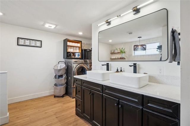 bathroom with washer / clothes dryer, vanity, and hardwood / wood-style floors