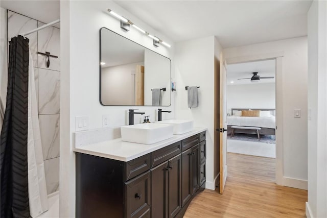 bathroom with hardwood / wood-style flooring, ceiling fan, vanity, and curtained shower