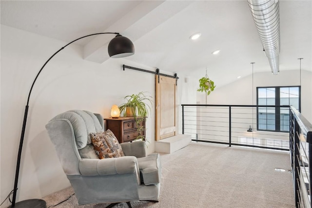 sitting room featuring a barn door, lofted ceiling, and carpet