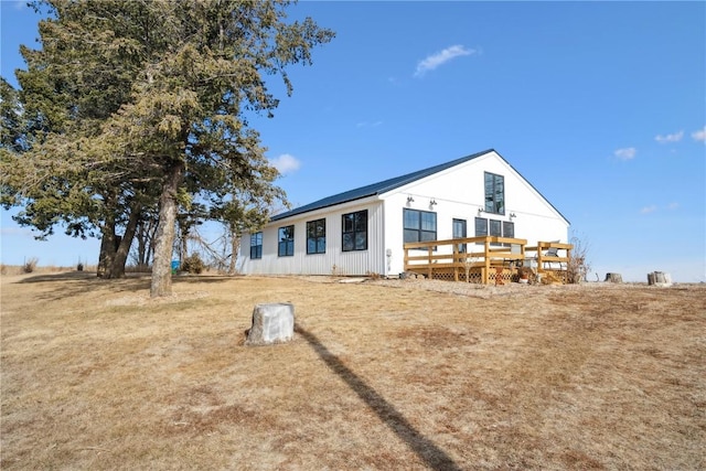 back of house featuring a lawn and a deck