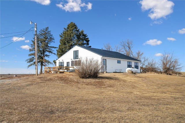 exterior space featuring a wooden deck and a lawn