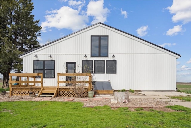 back of house featuring a lawn and a deck