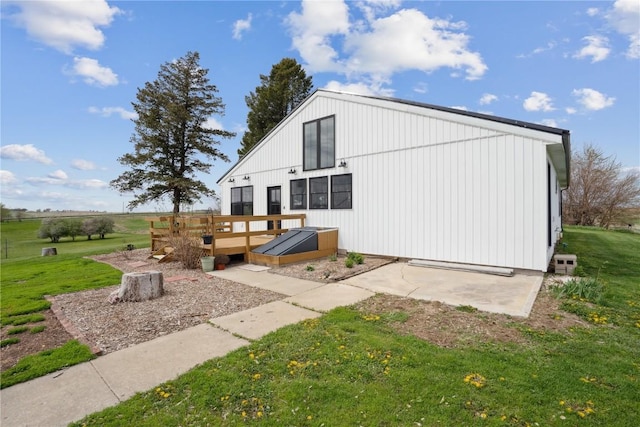rear view of property featuring a lawn and a deck