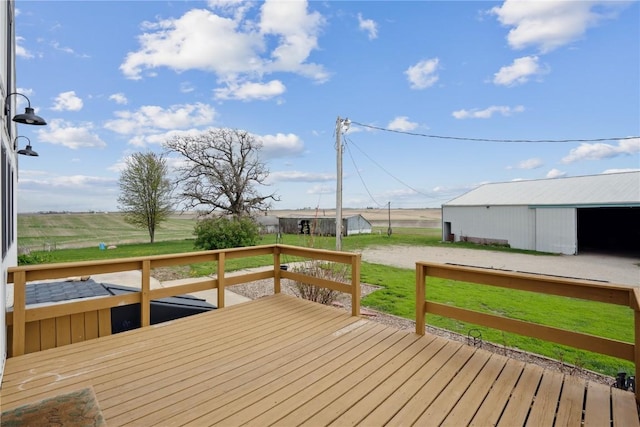 wooden terrace featuring a lawn and an outbuilding
