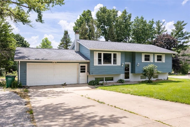 bi-level home featuring a garage and a front lawn