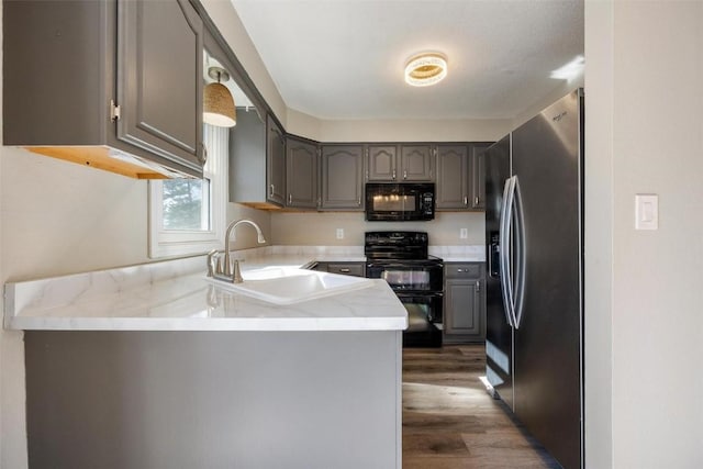 kitchen featuring sink, gray cabinetry, kitchen peninsula, and black appliances