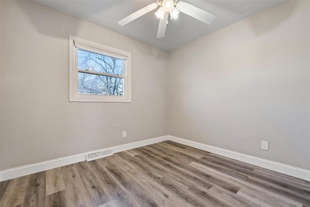 spare room with ceiling fan and wood-type flooring