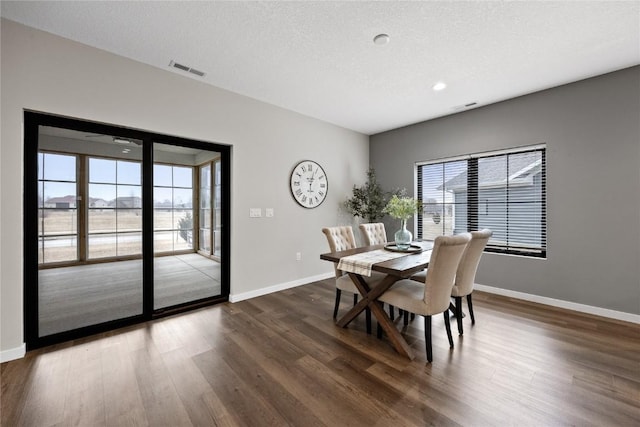 dining space featuring dark hardwood / wood-style floors and a textured ceiling