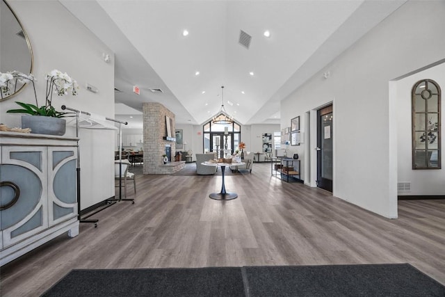 interior space with hardwood / wood-style flooring and high vaulted ceiling