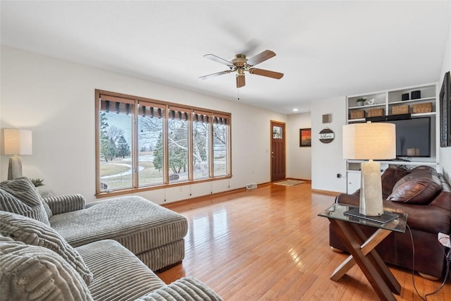 living room with light hardwood / wood-style flooring and ceiling fan