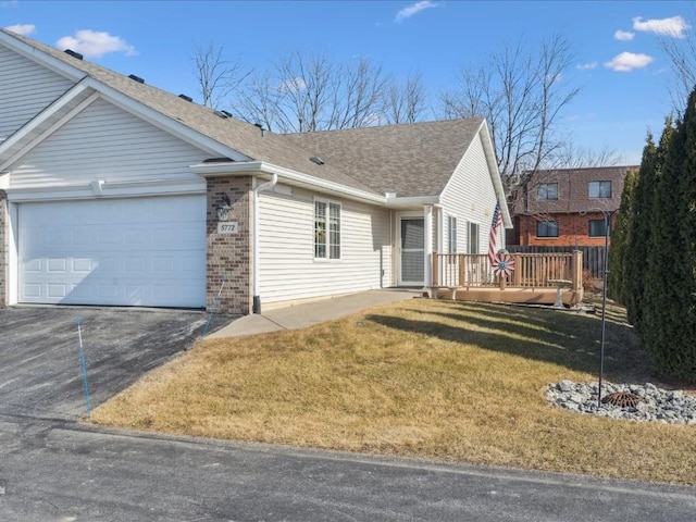 ranch-style home with a garage and a front lawn