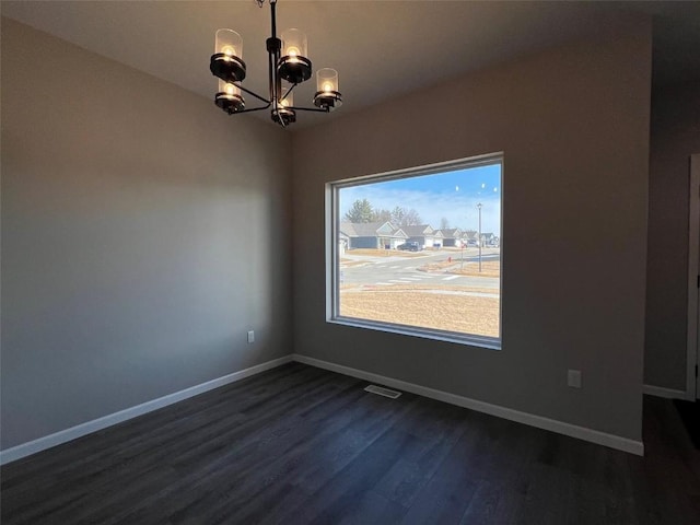 unfurnished dining area featuring a notable chandelier and dark wood-type flooring