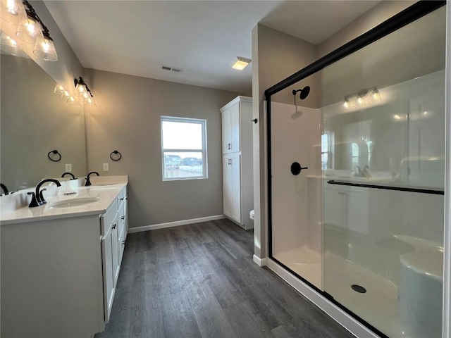 bathroom with a shower with door, wood-type flooring, vanity, and toilet