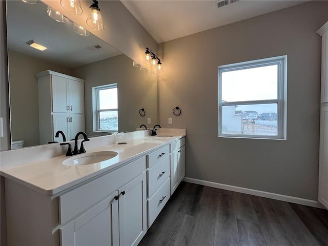 bathroom with hardwood / wood-style flooring, vanity, and toilet