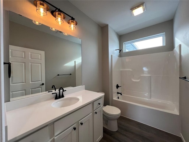 full bathroom with hardwood / wood-style flooring, shower / bathtub combination, vanity, and toilet