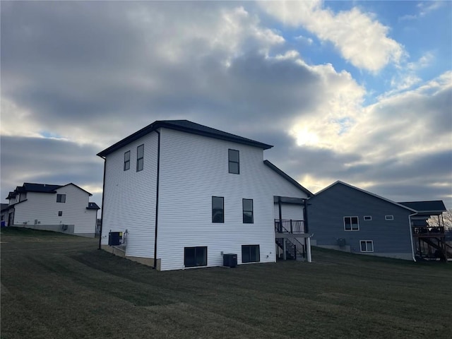 view of side of property with cooling unit and a lawn