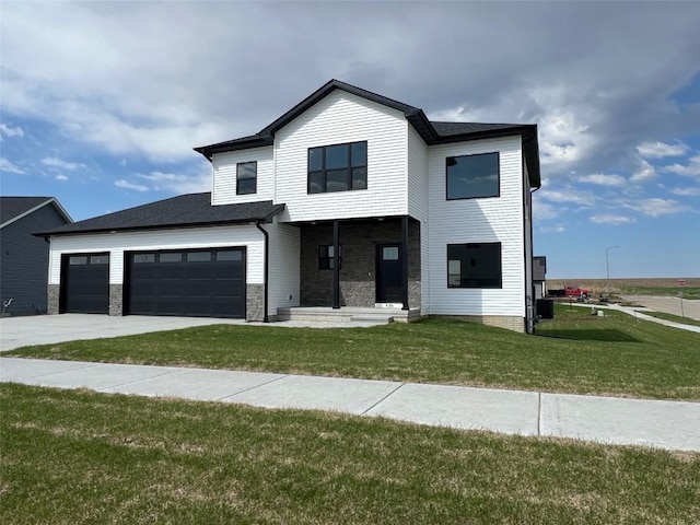 modern inspired farmhouse with concrete driveway, an attached garage, stone siding, and a front yard