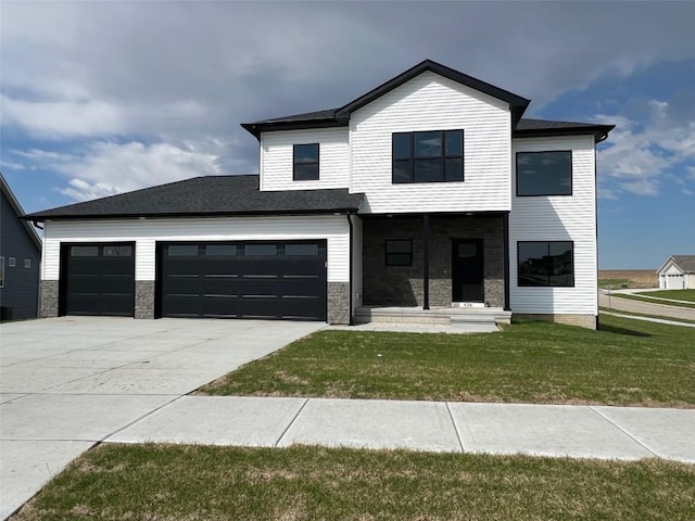 view of front of home featuring concrete driveway, a front lawn, stone siding, and a garage
