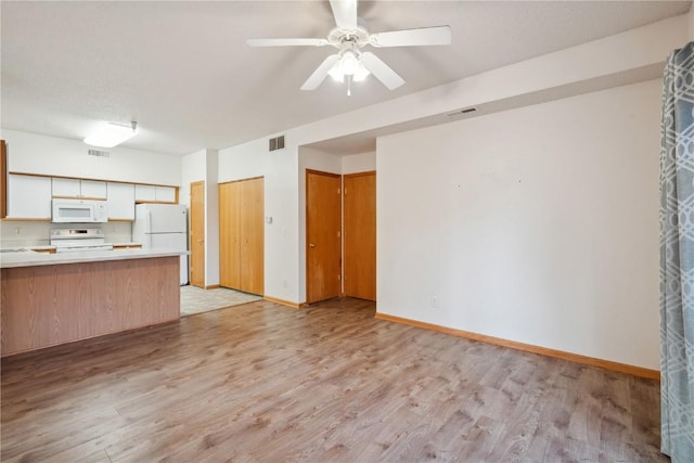 kitchen with ceiling fan, white appliances, kitchen peninsula, and light wood-type flooring