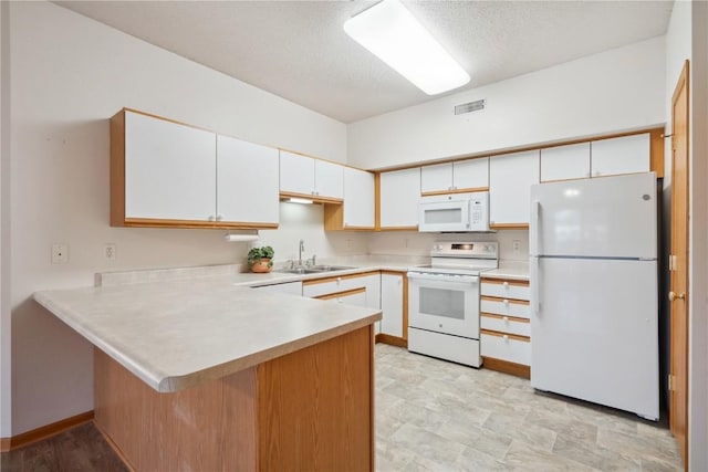 kitchen with sink, white cabinetry, a textured ceiling, kitchen peninsula, and white appliances