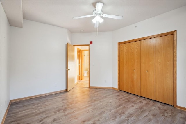 unfurnished bedroom featuring ceiling fan, light wood-type flooring, and a closet