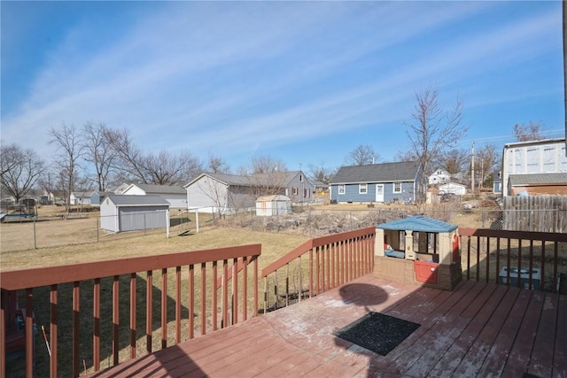 wooden deck featuring a yard and a storage unit