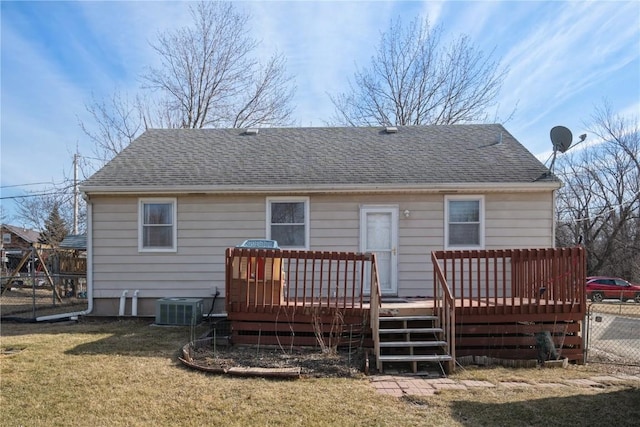 back of property with a wooden deck, a yard, and central air condition unit