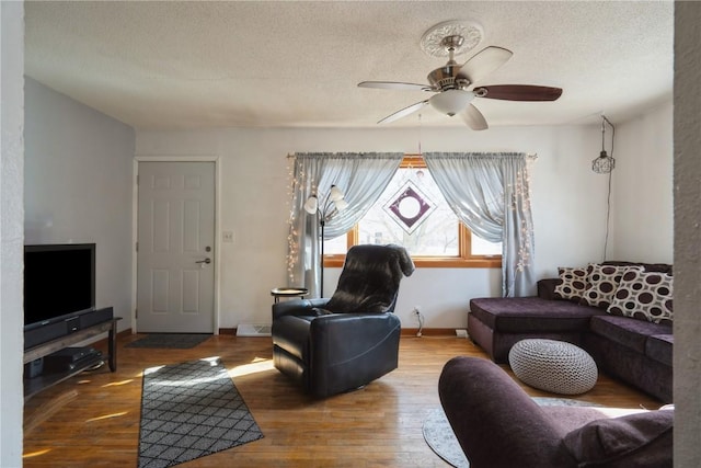 living room with ceiling fan, hardwood / wood-style floors, and a textured ceiling