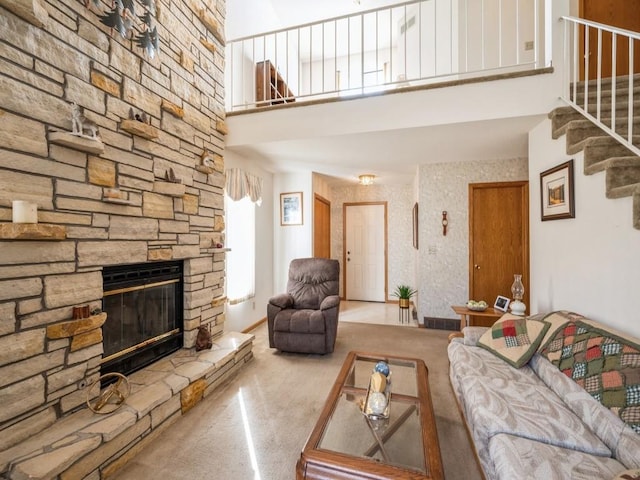 living room featuring carpet floors, a towering ceiling, and a fireplace