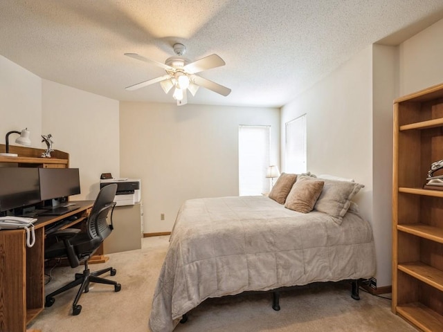 carpeted bedroom featuring ceiling fan and a textured ceiling