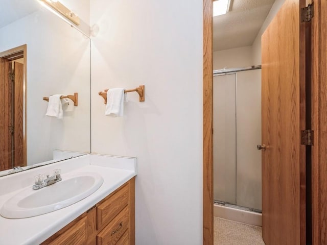 bathroom with vanity and a shower with shower door