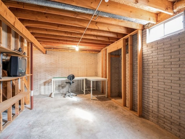 basement featuring brick wall