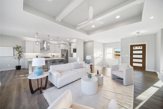 living room featuring ceiling fan, dark hardwood / wood-style flooring, a raised ceiling, and beam ceiling