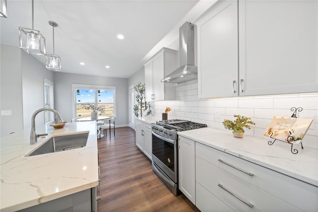 kitchen with sink, white cabinetry, stainless steel range with gas stovetop, pendant lighting, and wall chimney range hood