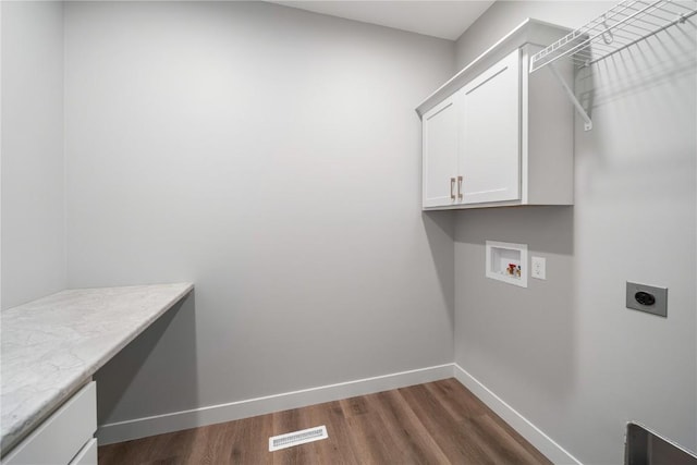 washroom with cabinets, hookup for a washing machine, dark wood-type flooring, and hookup for an electric dryer