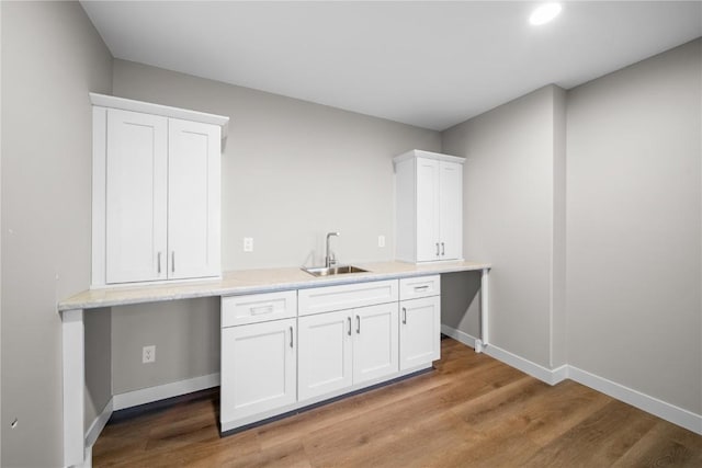 kitchen featuring white cabinetry, sink, and light hardwood / wood-style flooring