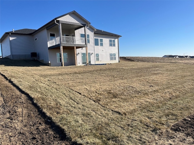 rear view of property with cooling unit, a yard, and a balcony