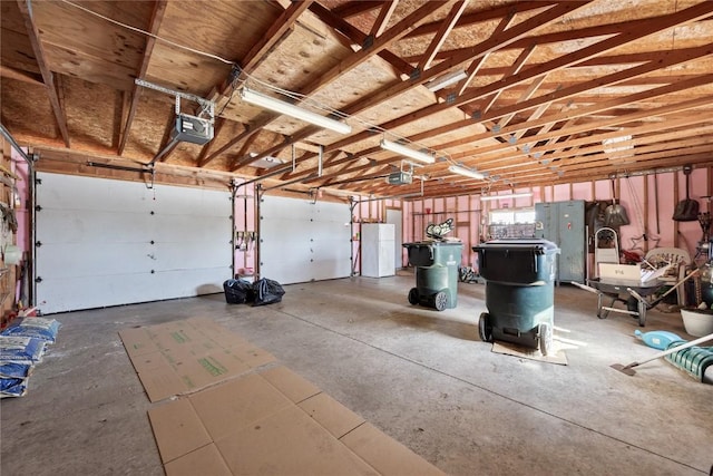 garage featuring freestanding refrigerator and a garage door opener