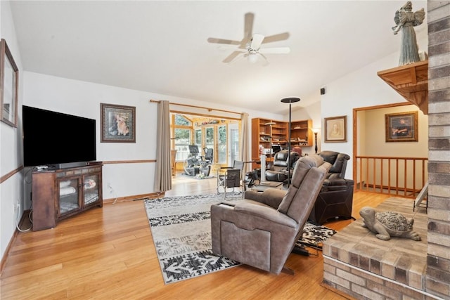 living room featuring ceiling fan, wood-type flooring, and vaulted ceiling