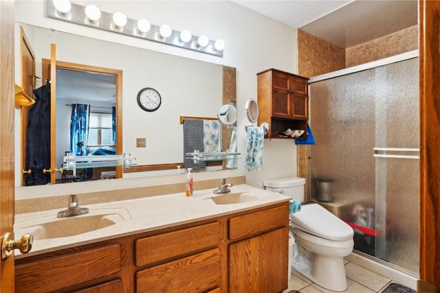 bathroom with tile patterned floors, toilet, an enclosed shower, and vanity