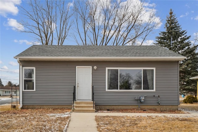 bungalow-style home featuring entry steps and a shingled roof