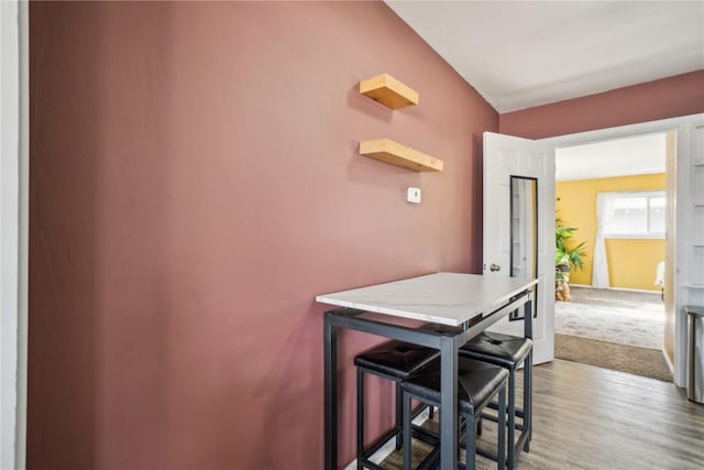 kitchen featuring a kitchen bar and wood finished floors