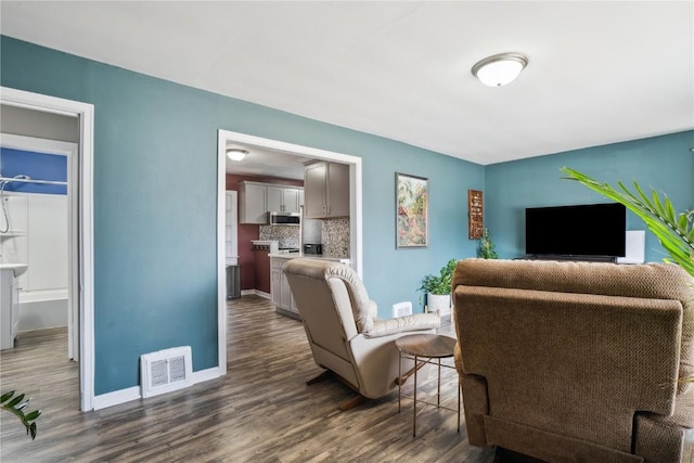 living room featuring baseboards, visible vents, and dark wood finished floors