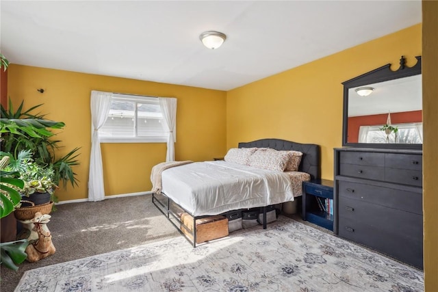 bedroom featuring light carpet and baseboards